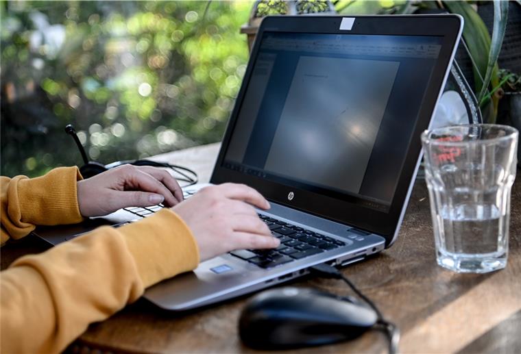Homeoffice in der Kritik - Keine höhere Produktivität? Berlin: Eine junge Frau arbeitet im Homeoffice in einem Wintergarten.