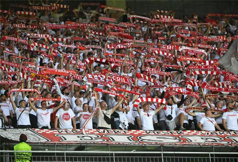 Die Fans von Union Berlin halten ihre Schals hoch.