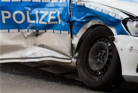 Die Beifahrertür eines Polizeifahrzeug ist nach einem Unfall stark verbeult.