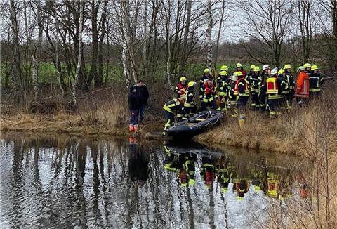 Die Einsatzkräfte der Feuerwehr lassen ein Schlauchboot zu Wasser.