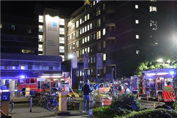 Einsatzkräfte der Feuerwehr stehen nach einem Brand im Düsseldorfer Marien Hospital vor dem Krankenhaus.