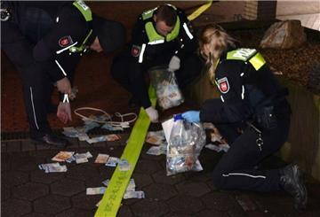 Einsatzkräfte der Polizei sammeln das Geld ein.