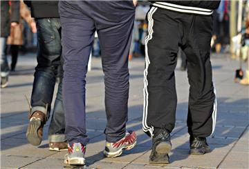 In Jogginghosen gehen junge Männer die Königstraße entlang.