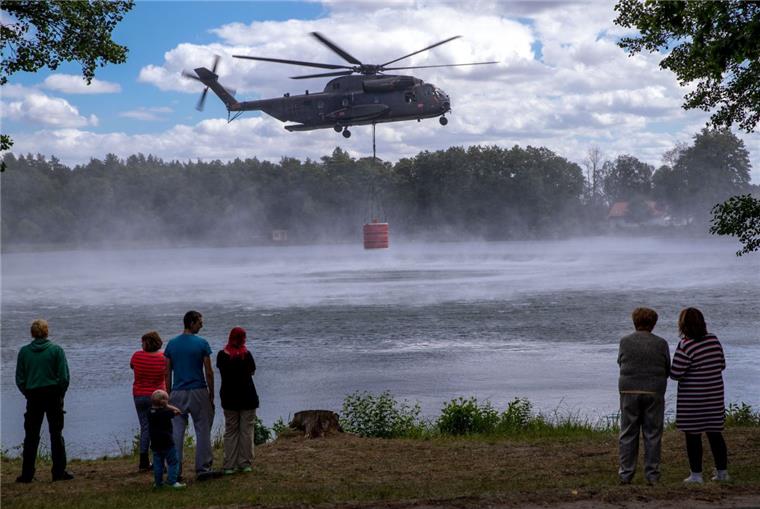 Brandbekämpfung auf Truppenübungsplatz bei Lübtheen wird forciert Einwohner und Urlauber beobachten einen Hubschrauber CH53 der Bundeswehr beim Aufnehmen von 5000 Liter Löschwasser in einem See.
