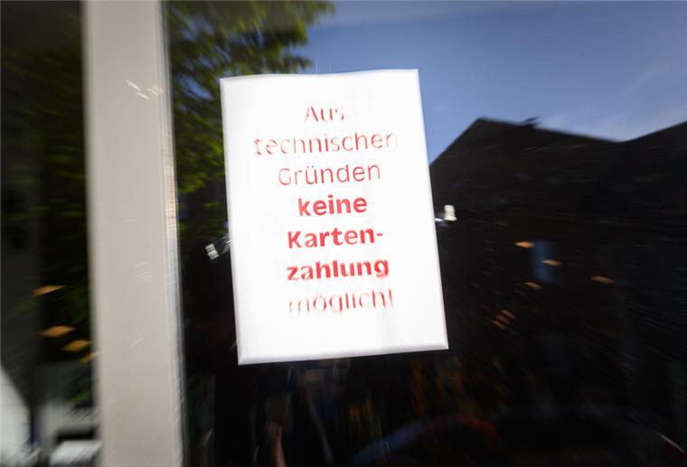 Ein Schild mit der Aufschrift "Aus technischen Gründen keine Kartenzahlung möglich!" hängt am Eingang eines Supermarktes. 