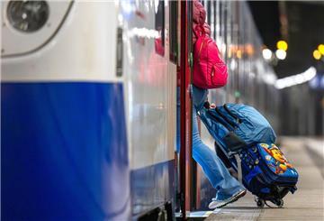 Eine Frau mit Koffern steigt in einen Regiozug von Nordwestbahn
