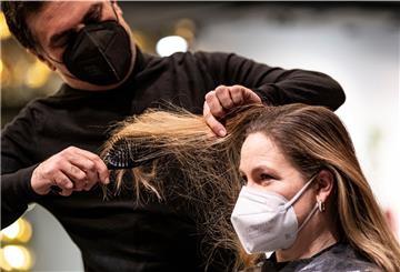 Shan Rahimkhan, Friseur, begutachtet die Haare der ersten Kundin seines Friseurladens nach der Wiedereröffnung. Nach wochenlanger Schließung öffnen in Berlin die Frisiergeschäfte wieder. 
