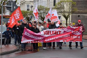 Entlang der Bahnhofstraße zeigen die Mitglieder der Gewerkschaften und Parteien Flagge – und trotzen dabei Kälte und Regen.