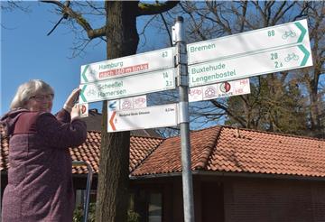 Erika Jaschinski, die Leiterin des Touristik-Büros der Samtgemeinde Sittensen, wäscht die Schilder an den Rad- und Wanderwegen in der Börde Sittensen.