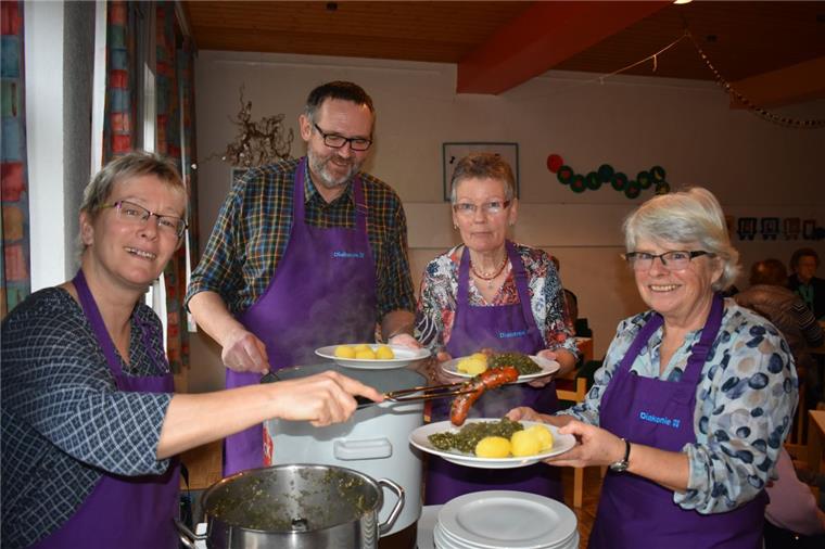 Erst kochen die Ehrenamtlichen das Essen, dann bringen sie es den Gästen an die Tische. Antje Plenter-Böning (von links), Walter Janßen, Birgit Kolschen und Hilke Freese servieren im Gemeindehaus in Seefeld Grünkohl mit Pinkel und Salzkartoffeln.
