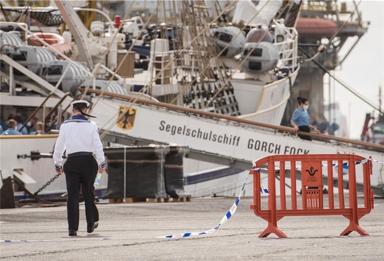 Mann läuft vor dem Segelschulschiff "Gorch Fock" über ein Flatterband.