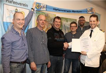 Erster Hafenmeister Tobias Brunkhorst zeichnet den Leichtmatrosen Andreas Stahnke (Dritter von links) für seine außerordentlichen „strömischen Verdienste“ mit dem Titel „Watt’n Elektriker“ aus.