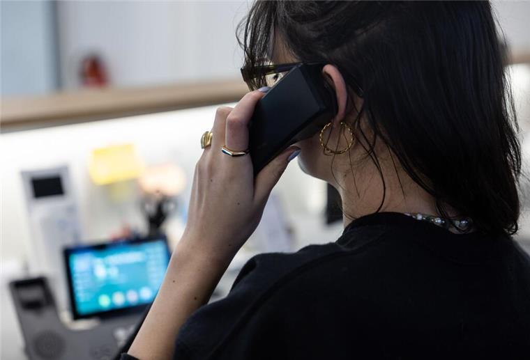 In Deutschland wurde 2024 weniger gearbeitet ILLUSTRATION - Eine Frau sitzt an einem Schreibtisch in einem Büro und telefoniert. (zu dpa: «Psychische Gewalt am Arbeitsplatz bleibt oft unsichtbar»)