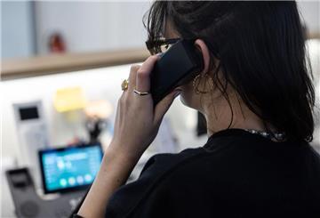ILLUSTRATION - Eine Frau sitzt an einem Schreibtisch in einem Büro und telefoniert. (zu dpa: «Psychische Gewalt am Arbeitsplatz bleibt oft unsichtbar»)