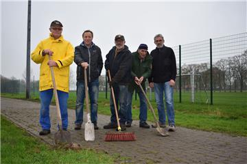 Erwin Tanzen (von links), Gunther Wagner, Horst Rebmann, Reiner Gebauer und Frank Dönselmann reinigen die Zuwegung, die von den Umkleidekabinen zum Kunstrasenplatz (Sportplatz) führt.