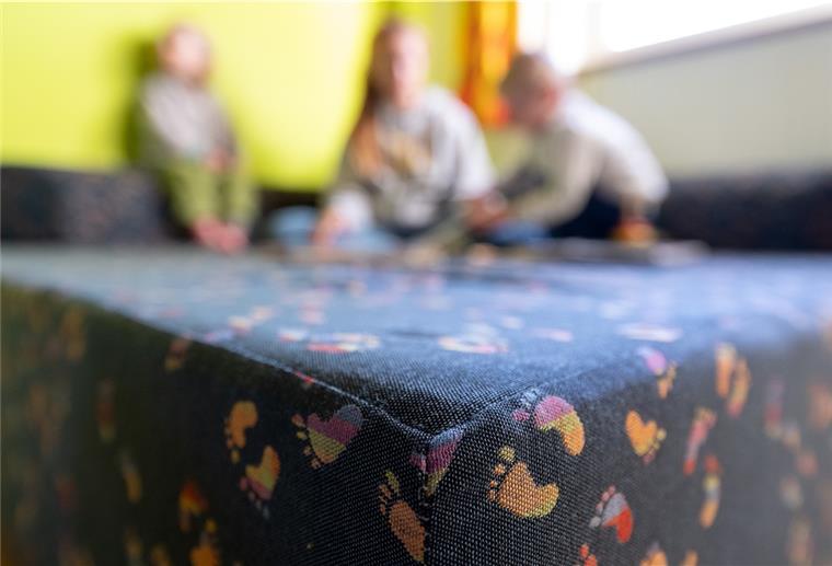 Kinder spielen auf einer Sitzecke. 