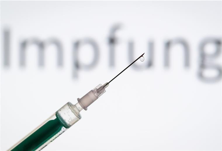 ordrhein-Westfalen, Bielefeld: ILLUSTRATION - Eine Spritze wird vor den Schriftzug «Impfung» gehalten. Pharmaunternehmen verkünden hoffnungsvolle Ergebnisse zu ihren Corona-Impfstoffen. Was bedeutet das?
