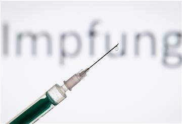 ordrhein-Westfalen, Bielefeld: ILLUSTRATION - Eine Spritze wird vor den Schriftzug «Impfung» gehalten. Pharmaunternehmen verkünden hoffnungsvolle Ergebnisse zu ihren Corona-Impfstoffen. Was bedeutet das?