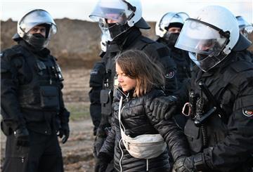 Polizisten führen die schwedische Klimaaktivistin Greta Thunberg (M) aus einer Gruppe von Demonstranten und Aktivisten heraus und vom Rand des Braunkohlentagebaus Garzweiler II weg. 