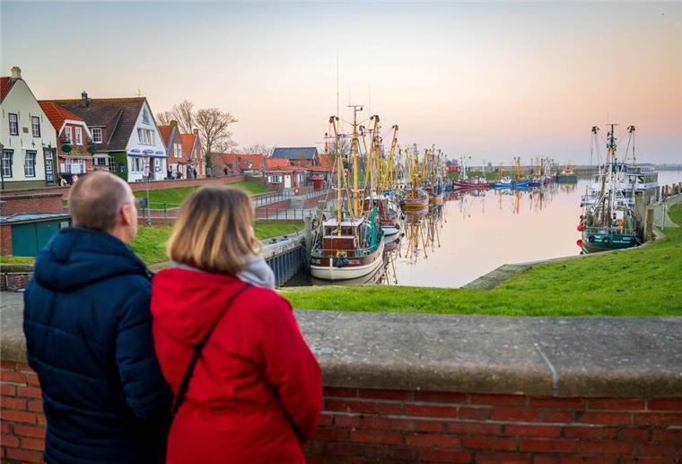 Tourismusbranche in Niedersachsen fast auf Vor-Corona-Niveau Touristen schauen auf die Krabbenkutter am Hafen.