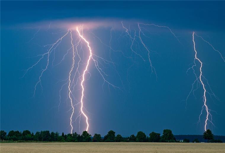 Blitze eines Gewitters leuchten am Abendhimmel im Osten des Landes Brandenburg. 