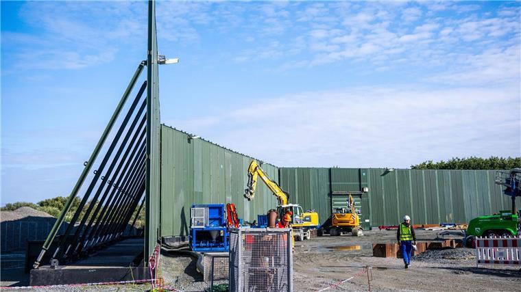 Windstrom durchs Watt leiten: Wie wird Norderney unterbohrt? Etwa zehn Meter hohe Lärmschutzwände schirmen die Baustelle ab.