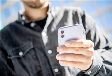 Ein Mann hat ein Handy in der Hand. 