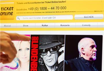 Ein Finger einer Frau zeigt auf einen Computermonitor mit einer Internetseite, auf der man Event-Tickets online bestellen kann