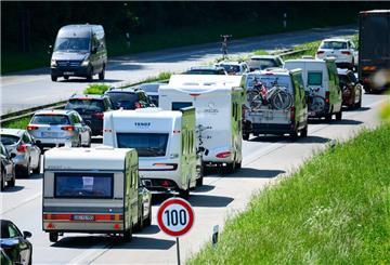 Autos, Wohnmobile und Transporter auf einer Autobahn im Stau.