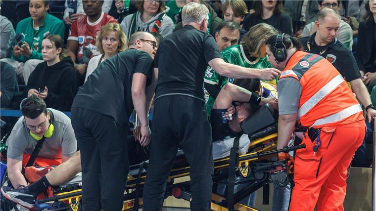 Trotz Remis: Füchse Berlin erreichen Viertelfinale Fabian Wiede wird schmerzverrt auf einer Trage aus der Halle gebracht