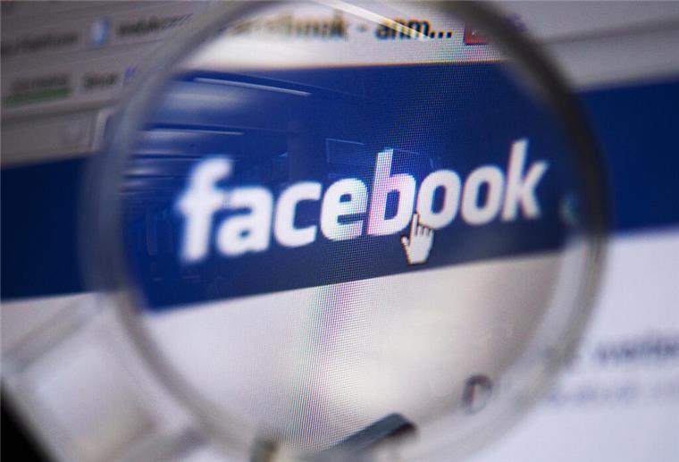 Sammelklage gegen Facebook: So sicherst du dir bis zu 600 Euro Schadenersatz Blick durch eine Lupe auf das Logo des sozialen Netzwerkes Facebook, aufgenommen am 04.02.2011 in Berlin