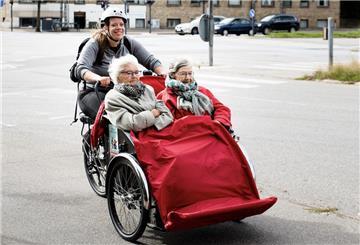 Zwei Seniorinnen fahren in der speziellen Senioren-Rikscha durch die Stadt.
