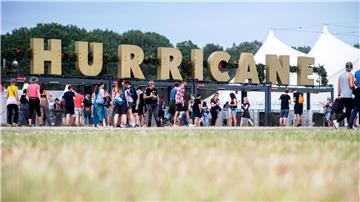 Festivalbesucher gehen 2022 am Haupteingang des Hurricane Festivals entlang.