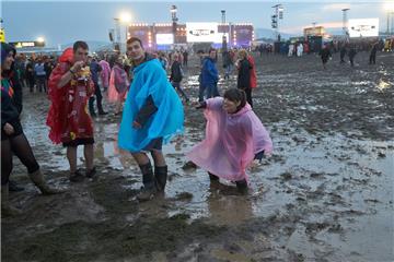 Festivalbesucher gehen beim Festival «Rock am Ring» nach einem Gewitterregen über das aufgeweichte Gelände.