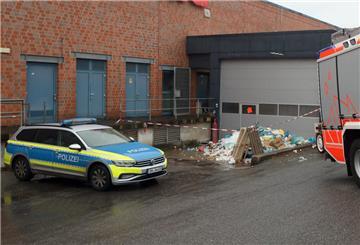 Feuerwehr und Polizei sind vor der Müllpresse eines Supermarkts im Einsatz. 