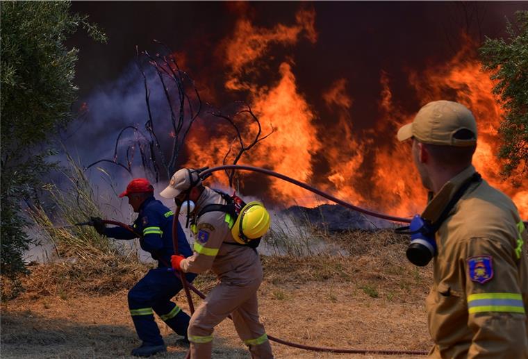 Feuerwehrleute bekämpfen einen Waldbrand in der Nähe der Stadt Olympia. Einsatzkräfte sind nach wie vor im Einsatz und bekämpfen Waldbrände. Das Feuer nördlich von Athen ist erneut voll aufgeflammt. 