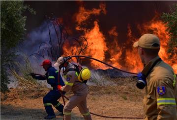 Feuerwehrleute bekämpfen einen Waldbrand in der Nähe der Stadt Olympia. Einsatzkräfte sind nach wie vor im Einsatz und bekämpfen Waldbrände. Das Feuer nördlich von Athen ist erneut voll aufgeflammt. 