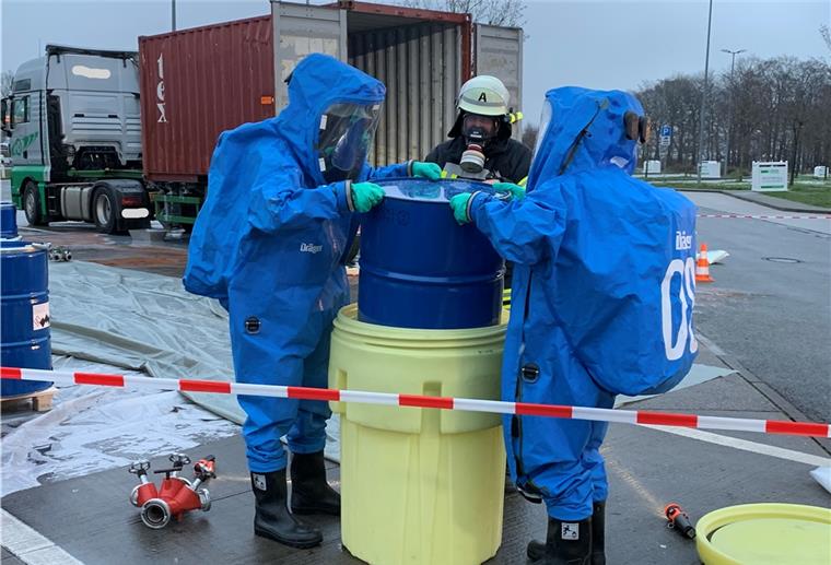 Sittensen: Alarm wegen gefährlicher Substanz Feuerwehrleute in spezieller Ausrüstung hoben das beschädigte Fass in ein größeres Fass.