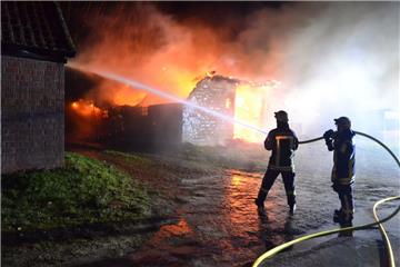 Feuerwehrleute löschen in der Nacht in Goldbeck eine reetgedeckte Scheune. 
