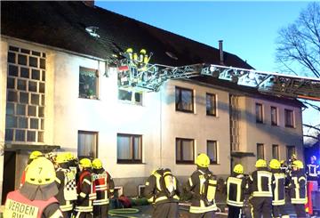 Feuerwehrleute sind bei einem Brand in einem Mehrfamilienhaus in Verden im Einsatz. 