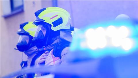 Feuerwehrleute stehen an einem Einsatzort.