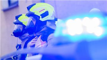 Feuerwehrleute stehen an einem Einsatzort.