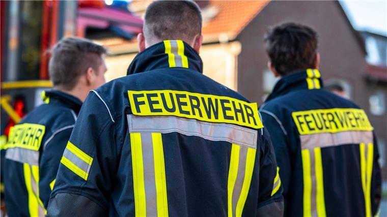 Feuerwehrleute stehen zusammen, um den Einsatz zu besprechen.