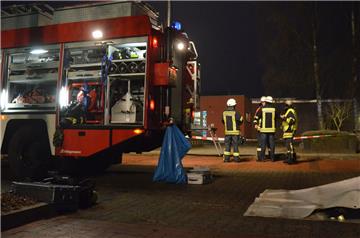 Feuerwehrleute und -wagen stehen vor dem Hallenbad in Zeven. 