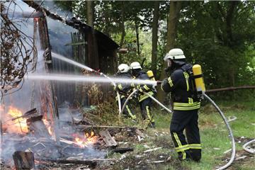 Feuerwehrmänner löschn die brennende Scheune.