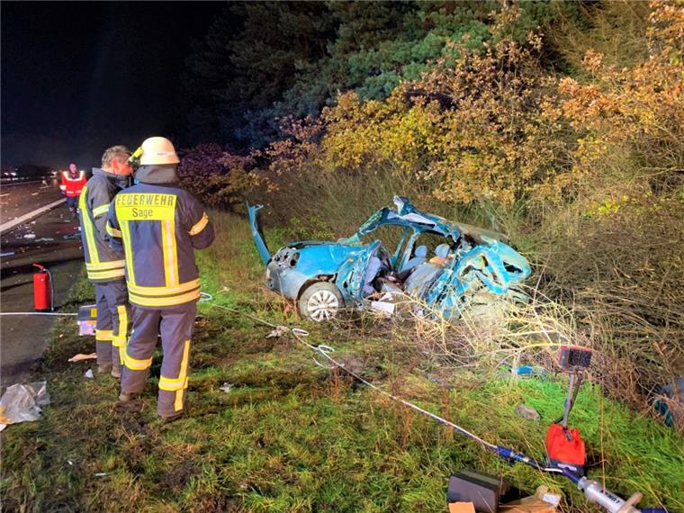 46-Jähriger stirbt nach Autounfall auf der A29 Feuerwehrmänner stehen an der Unfallstelle an der A29 bei Großenkneten.