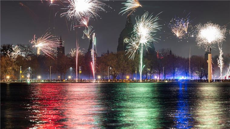 Feuerwerk explodiert am Himmel über dem Maschsee und dem Neuen Rathaus (Aufnahme mit langer Verschlusszeit).