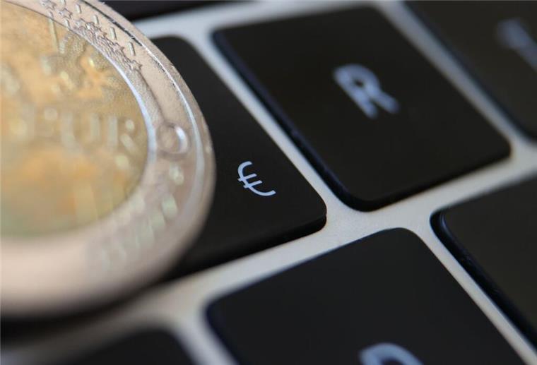 Ein Zwei Euro Geldstück liegt auf einer Tastatur.