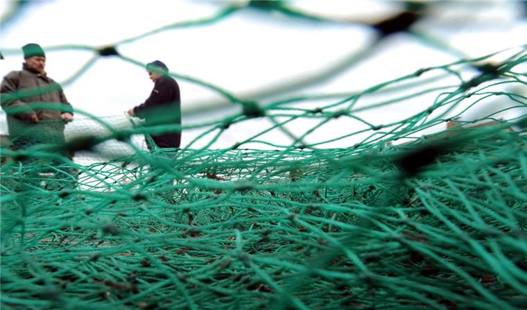 Fischer bereiten im Fischereihafen ihre Fangnetze für die nächste Fahrt vor.
