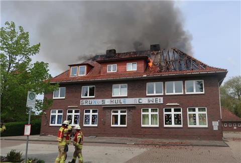 Flammen schlagen aus dem Dachstuhl der Grundschule Schwei. Die Ursache für das Feuer ist bislang unbekannt.